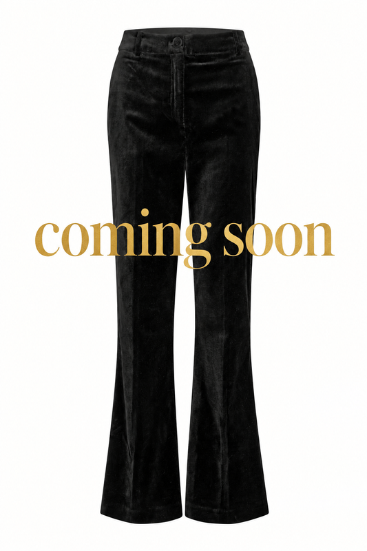 Black trousers with large gold “coming soon” lettering across the centre